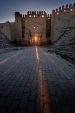 Sunbeams break through old city gates in ancient fortress wall at sunset, Bukhara, Uzbekistan
