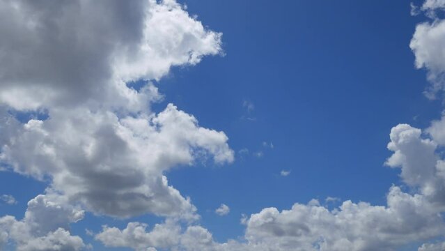 Blue summer sky with cloudy moving fast. Fast cloud formation and movement creating a surreal time lapse.