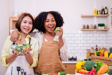 African American woman in white shirt by the window holds a mug in her hands.holding a cup of coffee or tea.Freedom life enjoy with hot drink beverage in a morning breakfast.Interior window curtain.