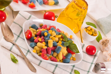 Colored gnocchi with vegetables and sweet corn.