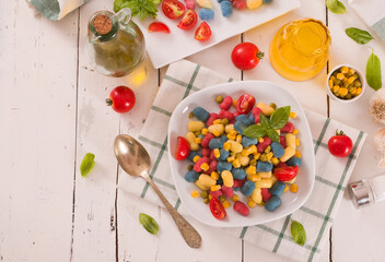 Fototapeta na wymiar Colored gnocchi with vegetables and sweet corn.
