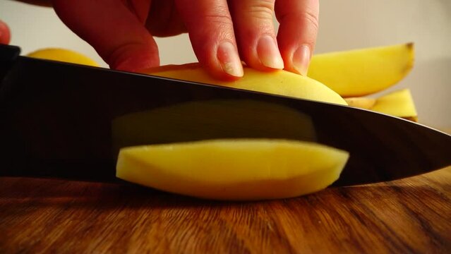 The cook cuts potatoes. Slow motion.