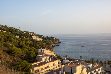 Obraz premium One of the few places man can live in natures beauty. Cropped shot of a city on the coastline with mountains surrounding it. 