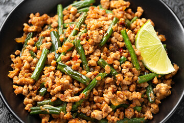 Pork Stir Fry with Green Beans, garlic, chili and ginger in black bowl. Asian food.