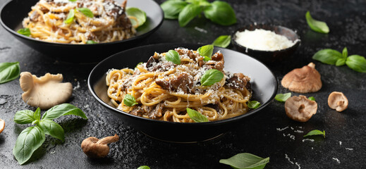 Porcini and woodland mushrooms pasta with pecorino cheese, basil in black bowl - obrazy, fototapety, plakaty