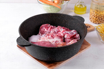 Assorted raw meat in cooking pan. Ingredients for preparing stew, potage, terrine or aspic