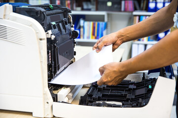 Technician hand open cover photocopier or photocopy to fix copier paper jam and replace ink cartridges for scanning fax or copy document in office workplace.