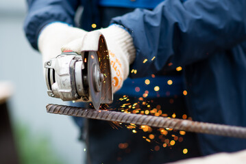 A man cuts iron with a grinder. Industry. A rare profession.