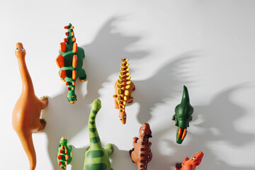 Toy dinosaurs with shadows on white background. Toys for Kids.  Games for learning and development of the child.