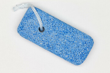 Bath pumice stone on the white background. Isolated. Blue pumice stone with large pores for the bathroom. Bathroom accessories. Object for body care. Cosmetic tool for care of the skin, legs, hands