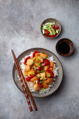 Sweet ad sour chicken served with steamed rice in black bowl - 528242712