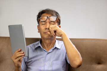 Senior asian man has eyestrain and fatigue