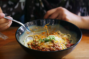 women eating cream pasta with sauce and meat on table 