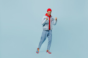 Full body side view young happy fun cool middle eastern man 20s he wear denim jacket red hat go do...