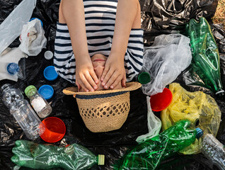 Environmental plastic pollution problem.  Boy on the background of garbage