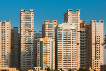 Fototapeta na wymiar New Residential Multi-storey Houses. Cityscape Skyline In Sunny Spring Evening On Blue Sky. Real Estate, Development Industry. UAE.