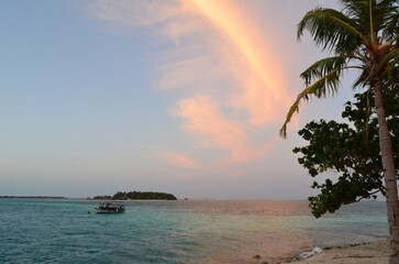 Ferry in turquoise sea at sunset of Maldives Islands