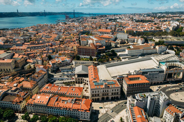 Aerial drone view of Rossio rail station looking west towards 25 April Bridge on Tagus River in...