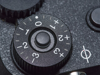 manual exposure compensation dial on a camera with one third increments to three stops.