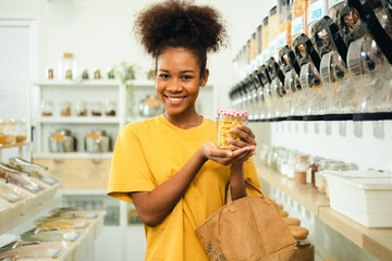 Young African American woman is choosing and shopping for organic products in refill store with reusable bag. No plastic Conscious Minimalism Vegan  sustainable plastic free Lifestyle Concept.