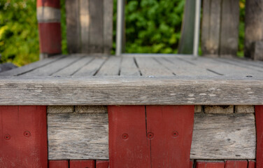 Frontal closeup of a wooden climbing frame in a children's playground. Front view without people. Wood. table edge. blurred background with slide.