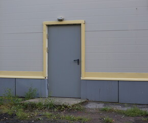 Obraz na płótnie Canvas Grey metal entrance door in a plastic wall