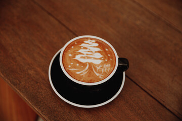 Tasty cappuccino with Christmas tree latte art on grey concrete background. Holiday concept.