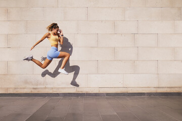 Fototapeta na wymiar Jumped woman with a shadow on a wall background.
