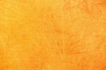 Golden wall with abstract spots as a background. Beautiful golden texture with patterns, decorative plaster. Modern bright wall painting in trendy shades, unusual spotted yellow and gold surface.