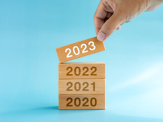 2023 Happy New year background. 2023 calendar numbers on wooden cube blocks stacked, building by...