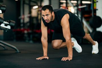 Fototapeta na wymiar Sporty Motivated African American Man Making Crossfit Training In Modern Gym