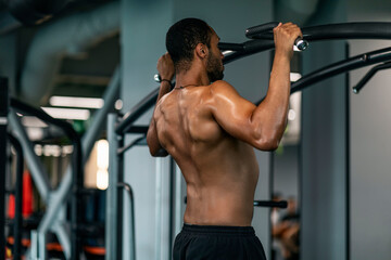 Plakat Athletic Young African American Man Pulling Up On Horizontal Bar At Gym
