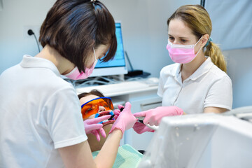 Woman patient with protective glasses and retractor for teeth whitening procedure