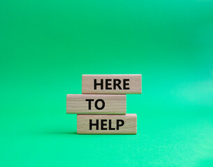 Here to help symbol. Wooden blocks with words Here to help. Beautiful green background. Business and Here to help concept. Copy space.