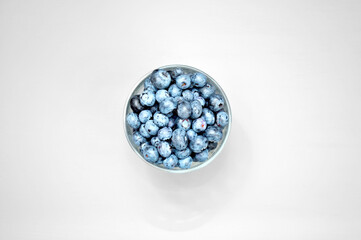 transparent glass mug with blueberries on white background