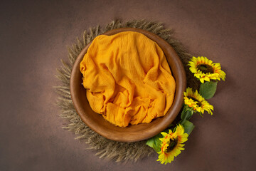 bowl made of wood, painted with sunflowers. basket for a photo session of a newborn. yellow sunflower flower. heart