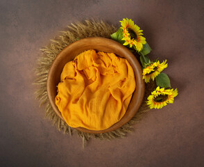 bowl made of wood, painted with sunflowers. basket for a photo session of a newborn. yellow sunflower flower. heart