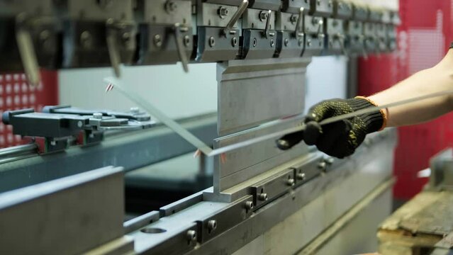 Operator working cut and bending metal sheet by high precision metal sheet bending machine, cnc control metal sheet bending machine in factory