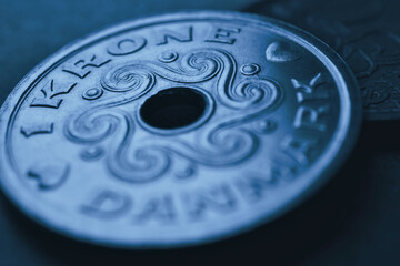 1 Danish krone coin closeup. National currency and money of Denmark. Dark blue tinted background for news about economy or finance. Loan and credit. Tax and inflation. Macro