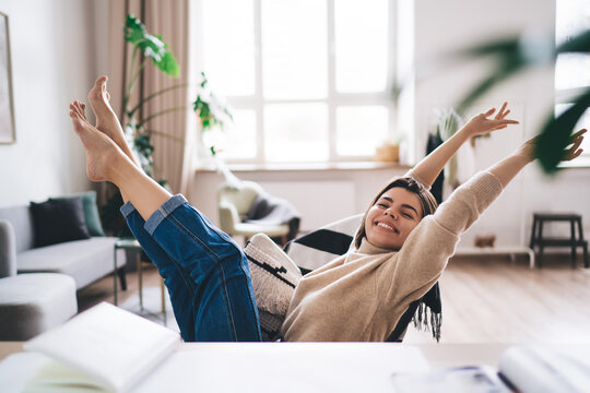 Lady rejoicing at finishing homework at table in living room