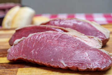 pedaços de picanha fatiados e colocados sobre a tábua de madeira para serem assados. Preparação para  churrasco.