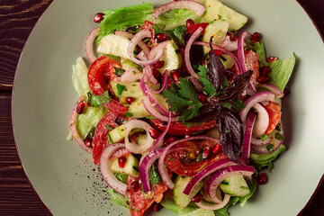 Georgian vegetable salad, tomatoes with cucumbers, red onion, walnut, pomegranate seeds, top view, no people,