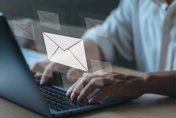 Fototapeta premium concept of technology the modern Internet responds to messages to customer e-mails. Man's hand typing on laptop keyboard with envelope icon showing communication between buyer and seller