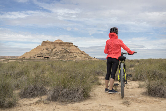 Young woman mountain bike cyclist in Badlans of Navarre (Bardenas Reales de Navarra) dessert in the middle of Spain.