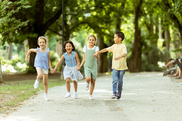 Fototapeta premium Group of asian and caucasian kids having fun in the park
