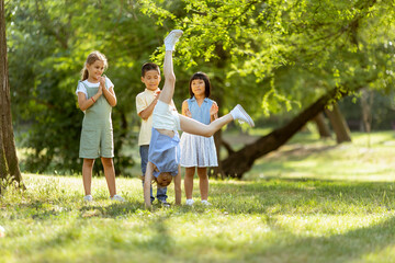 Fototapeta premium Group of asian and caucasian kids having fun in the park