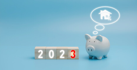 2023 on a wooden block cube with the white piggybank on blue background with copy space. The white piggy bank thinking of 2023 set goals for investment of property.