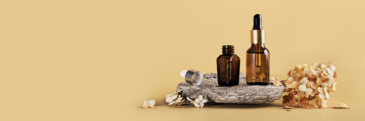 Amber glass bottles for branding mockup on stone podium and dried flowers. Eco friendly skincare beauty product concept