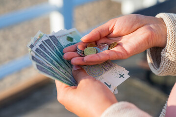 the girl holds in her hands banknotes money polish zlotys and pennies coins salary for payment
