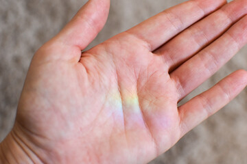 rainbow trace on human palm. rainbow reflection on hand